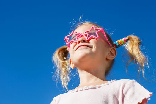 girl in sunglasses looking at the sky