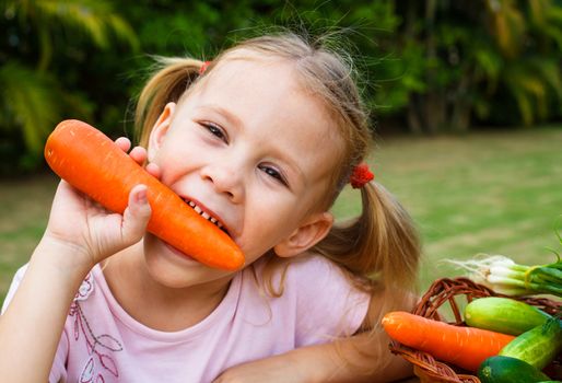 Happy little girl holding a carrots. Concept of healthy food.