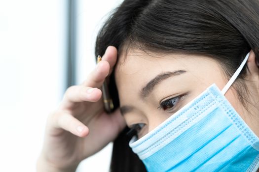 Close up woman with headache wearing  protective mask  for protection against virus Covid-19