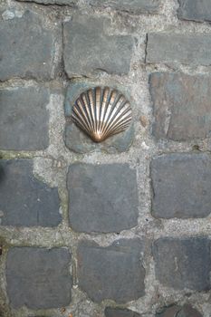 Brass shell in cobblestone on the street at Bruges