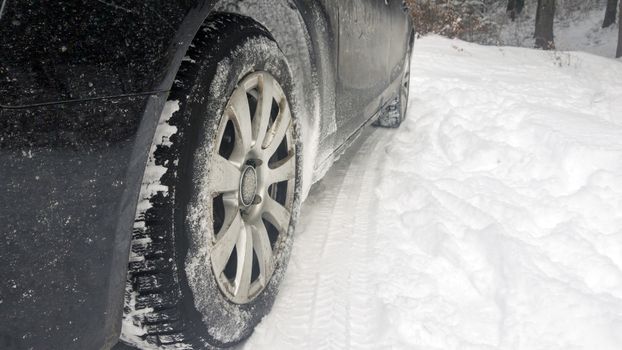 Car tires on winter road, covered with snow