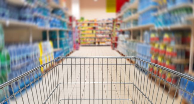 Speeding shopping cartin supermarket aisle.