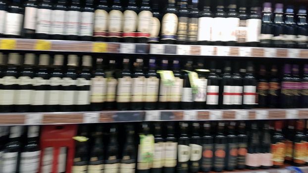 Wine bottles in a store shelf, supermarket aisle