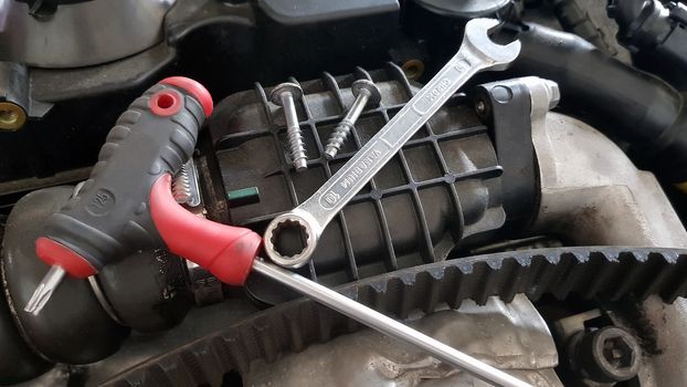 Service tools on car engine: spanner, screw, timing belt replace
