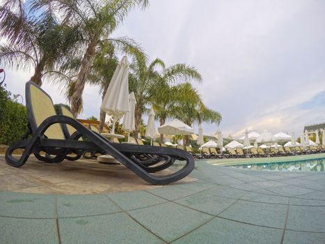 Summer resort: chaise longue near swimming pool in a mediterranean resort.