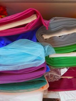 Rolls of fabric and textiles in seamstress workplace