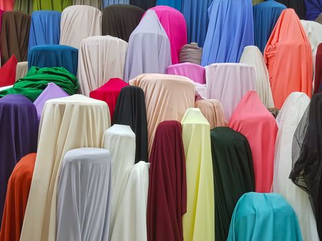 Colorful rolls of fabrics for sale in the market, textile industry store