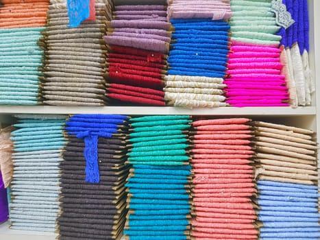 Traditional lace fabrics for sale, in the market, stack of colorful lace fabrics