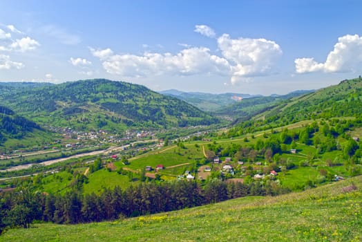 Spring contryside landscape, village and young green hills