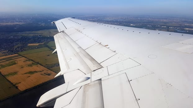 Departure plane wing above Bucharest, summer time airport departure