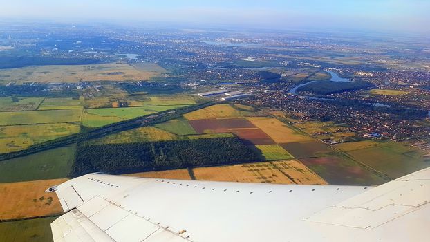 The wing of the plane taking off from Bucharest, aerial view of north of Bucharest