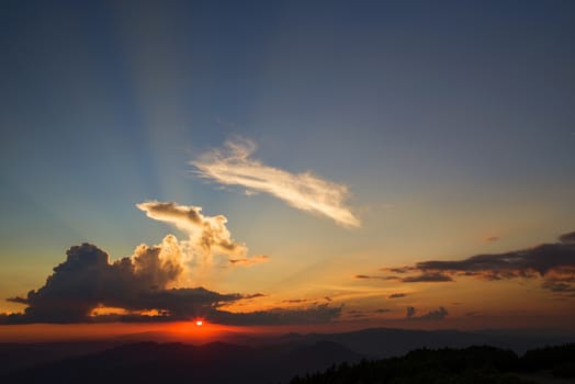 Sunset orange sun and clouds from the top of mountains