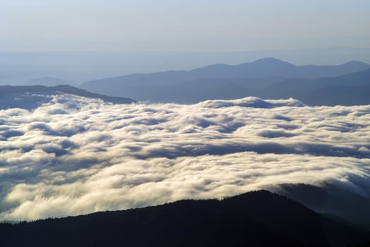 Clouds covering the river valley at sunrise, romanian Carpathians