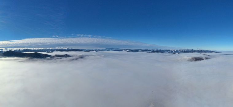 Aerial panorama of misty valley, dense fog in the morning