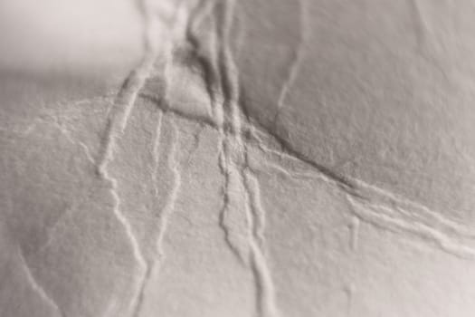 Soft Folds on Crumpled White Paper Texture. Macro Closeup.