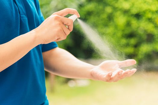 Asian delivery express courier young man use spray sterilize before giving boxes to woman customer receiving both protective face mask, under curfew quarantine pandemic coronavirus COVID-19