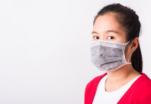 Asian adult woman wearing red shirt and face mask protective against coronavirus or COVID-19 virus or filter dust pm2.5 and air pollution she looking camera, studio shot isolated white background