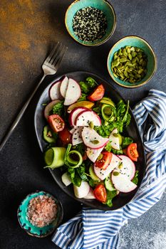 Healthy lifestyle food concept with mixed vegetable salad and seeds on rustic stone background with copy space