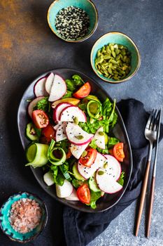 Healthy lifestyle food concept with mixed vegetable salad and seeds on rustic stone background with copy space