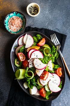 Healthy lifestyle food concept with mixed vegetable salad and seeds on rustic stone background with copy space