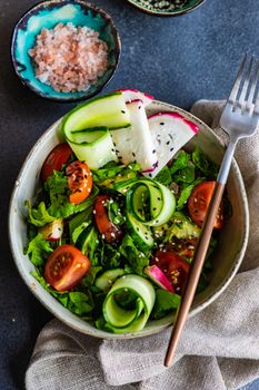 Healthy lifestyle food concept with mixed vegetable salad and seeds on rustic stone background with copy space