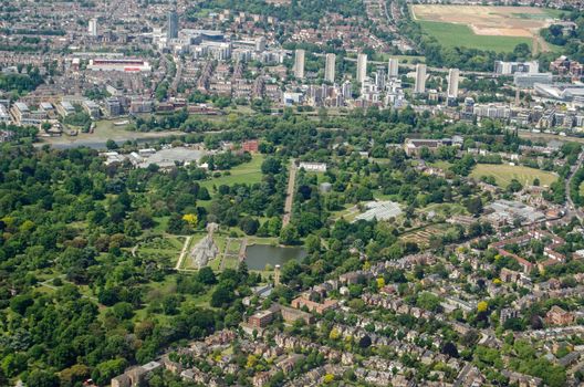 Aerial view of the historic Royal Botanic Gardens at Kew in West London on a sunny summer day.  The Palm House is in the middle of the image with Brentford Football Club's stadium to the top left.  