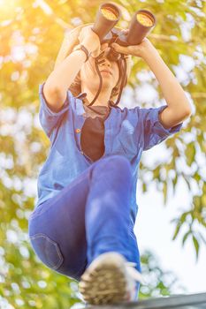 Close up Young asian woman short hair wear hat and hold binocular in grass field countryside Thailand