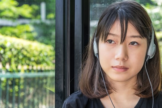 Teenage female with headphones and listening to music from mobile phone  at home