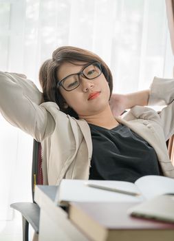 Teenage girl short hair relaxed after working on laptop while sit near window at home office