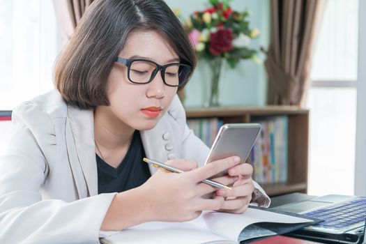 Teenage girl short hair in smart casual wear working on laptop while sit near window at home office