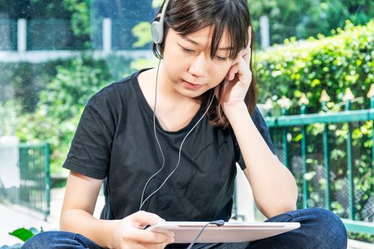 Happy teenage female  learning to the music from a digital tablet in room at home