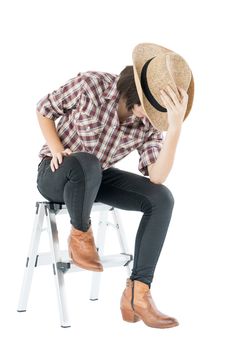 Young pretty woman in a cowboy hat and plaid shirt posing in studio with isolated on white background