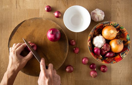 Cutting an onion on chopping board