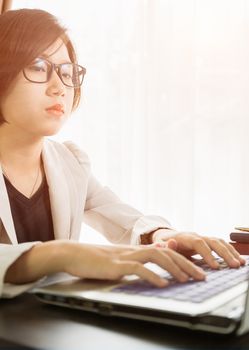 Woman teenage short hair in smart casual wear working on laptop while sit near window in home office