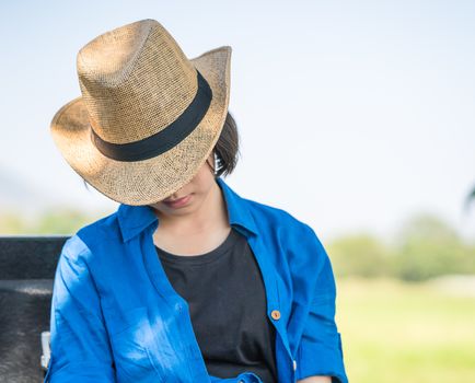 Young asian women short hair wear hat sit sleep in countryside Thailand