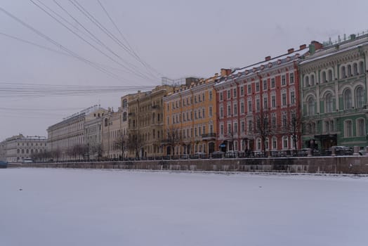 Embankment of ice covered Moyka river in snow weather. Saint Petersburg. Russia