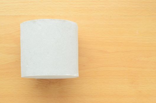 Top view, roll of toilet paper on wooden background.Space for text
