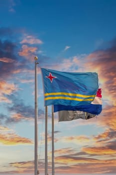 Flag of Aruba on flagpole under blue skies
