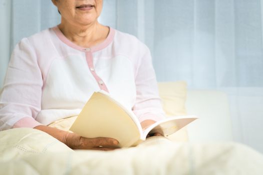 Covid-19 quarantine activity for senior woman read a book stay home to avoid risk