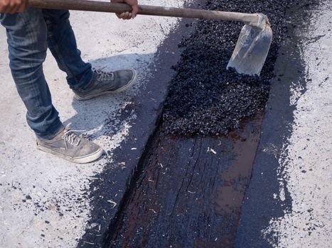 Worker use vibratory plate compactor compacting asphalt at road repair