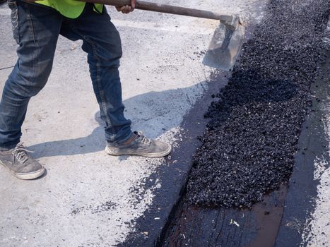 Worker use vibratory plate compactor compacting asphalt at road repair