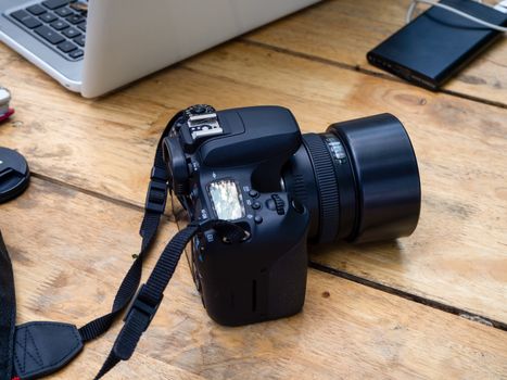 Wood photographter office desk table with digital camera and lens and computer tools