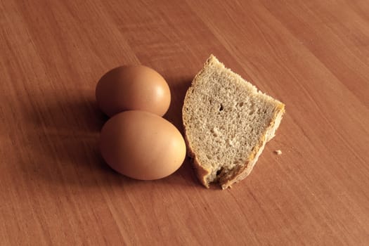 Two eggs and a slice of bread are on the table