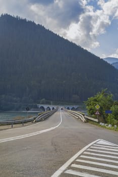 Crossing road on bridge, mountain river valley.