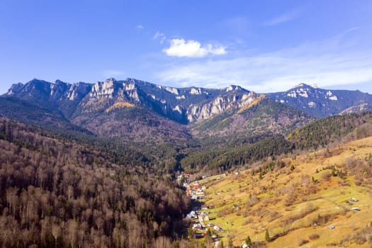 Aerial view of Izvorul Muntelui resort and Ceahlau massif in Romania, autumn mountain landscape