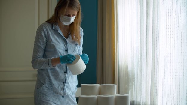 Coronavirus panic buying. Young woman examining toilet paper stocks that she bought in connection with the epidemic. Covid-19 pandemic