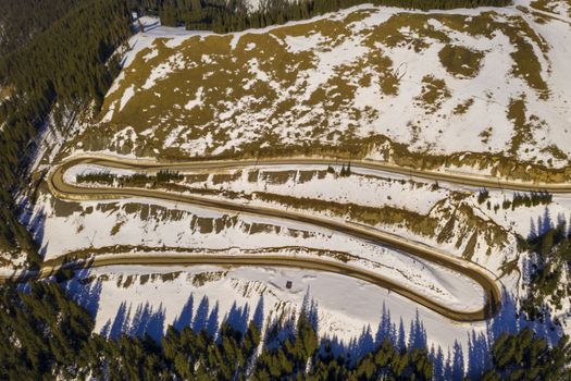 Winter curvy road in Rarau mountains, aerial scene in Romanian Carpathians.