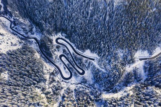 Winter mountain road from above, mountain curvy pass through the Romanian Carpathians.