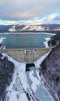 Water barriere dam viewed from above, dam and road on it in the winter. Bicaz Dam in Romanian Carpathians.