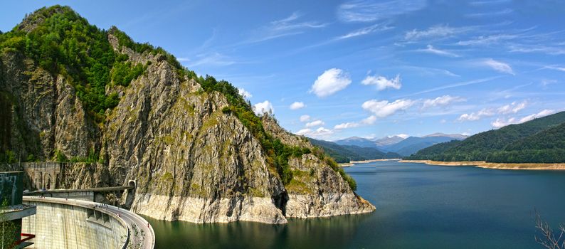 Energy dam and rocky mountain, summer landscape in Romanian Carpathians.